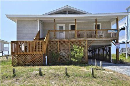 a house with a large deck with a porch at Charisma in Holden Beach