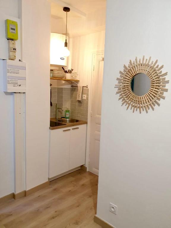 - une cuisine blanche avec un miroir mural dans l'établissement Home Sweet Home Sacré-Coeur Montmartre, à Paris