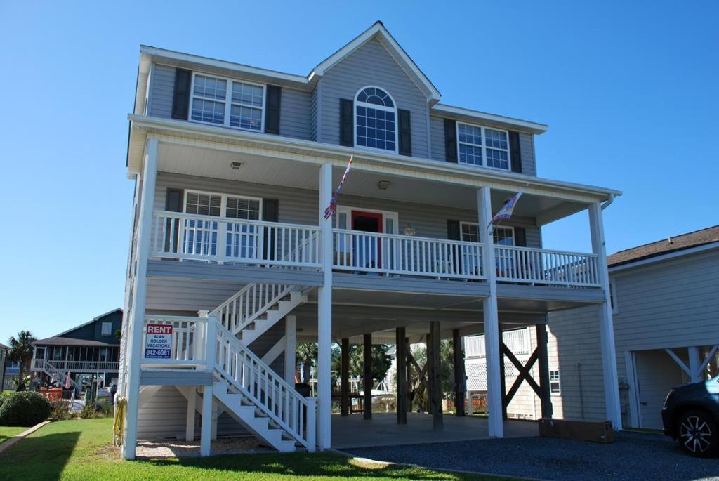 Casa grande con escaleras blancas y porche en Dibbs on Holden, en Holden Beach