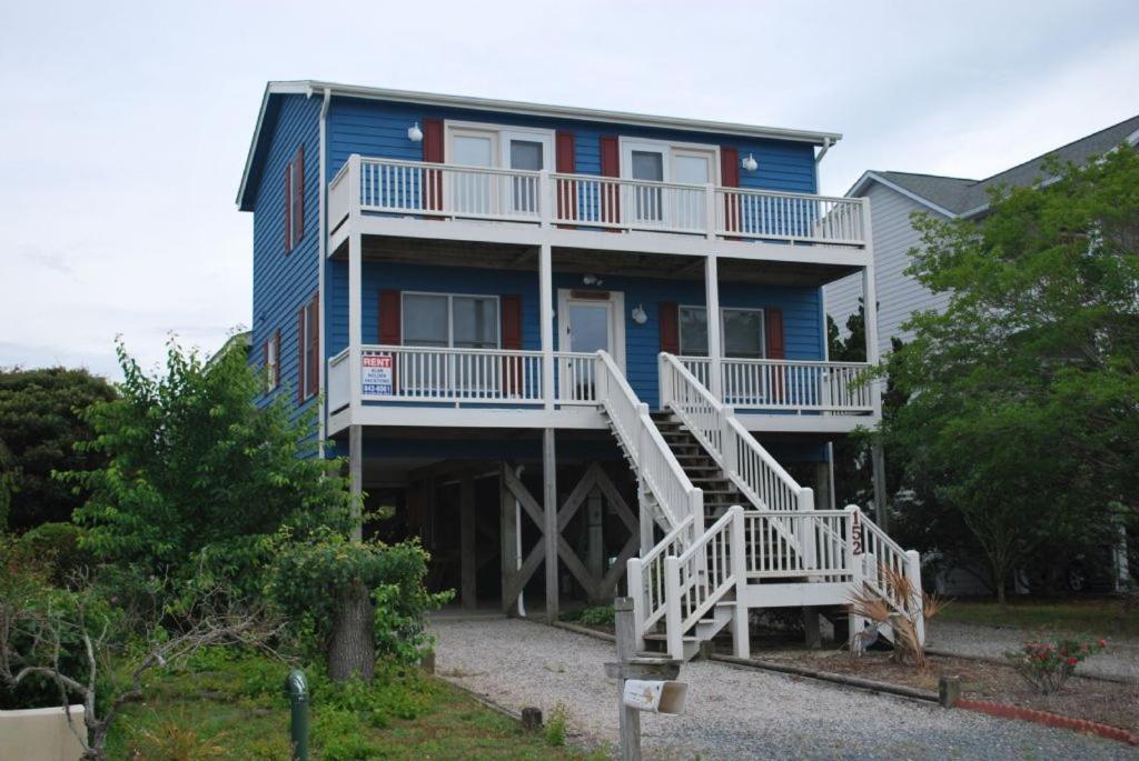 una casa azul con escaleras blancas delante en Flip Flop Inn, en Holden Beach