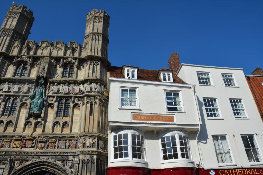 ein Gebäude vor einem Gebäude mit einem Uhrturm in der Unterkunft Cathedral Gate in Canterbury