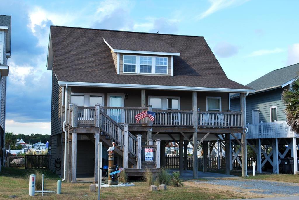 een huis met een Amerikaanse vlag ervoor bij Galleria in Holden Beach