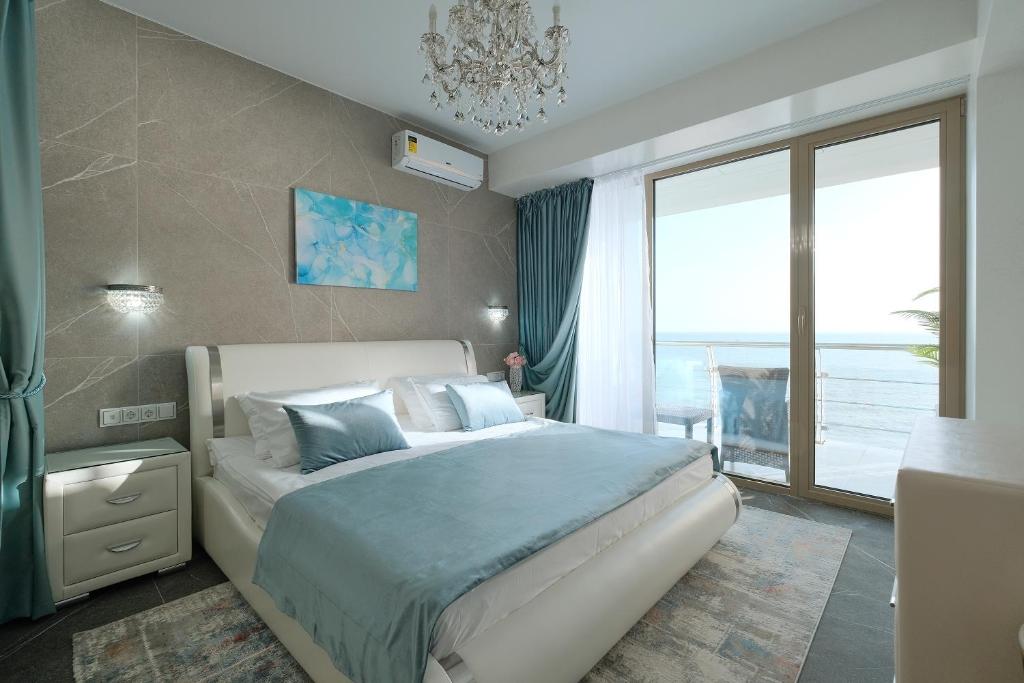 a bedroom with a large bed and a large window at "Serenity Premium apartments" с панорамным видом на море in Sochi