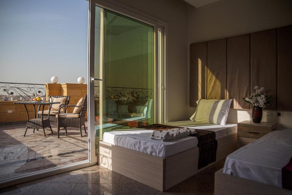 Een bed of bedden in een kamer bij Gardenia Pyramids view inn