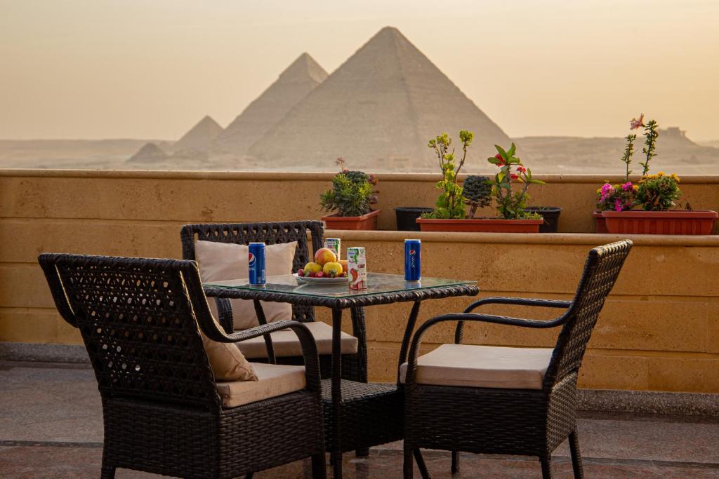 een tafel en stoelen met uitzicht op de piramides bij Gardenia Pyramids view inn in Caïro
