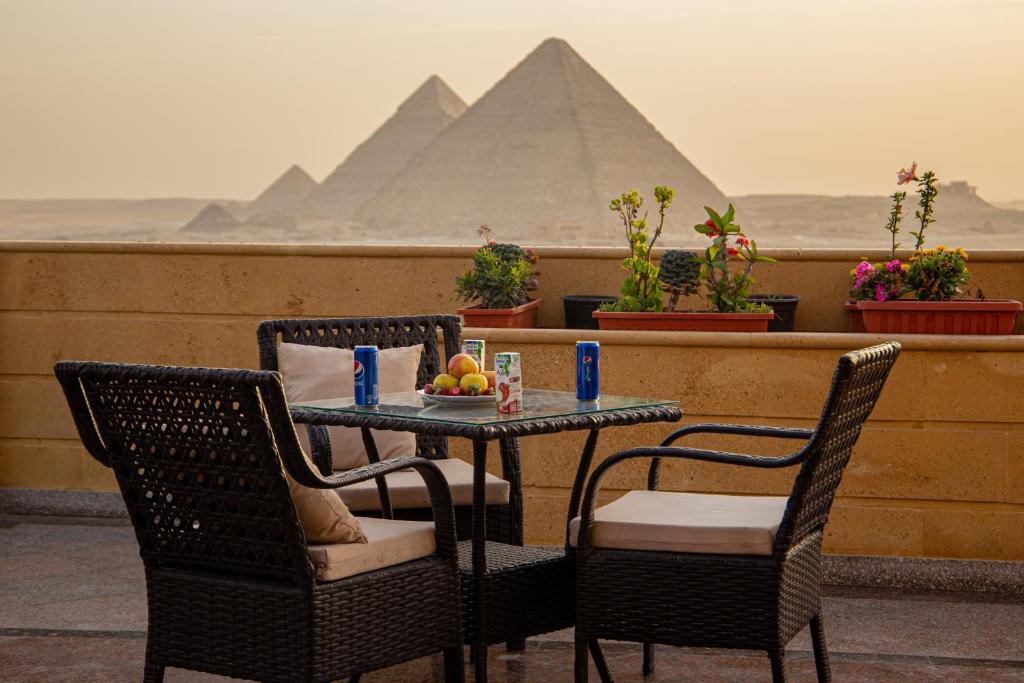 a table and chairs with a view of the pyramids at Gardenia Pyramids view inn in Cairo