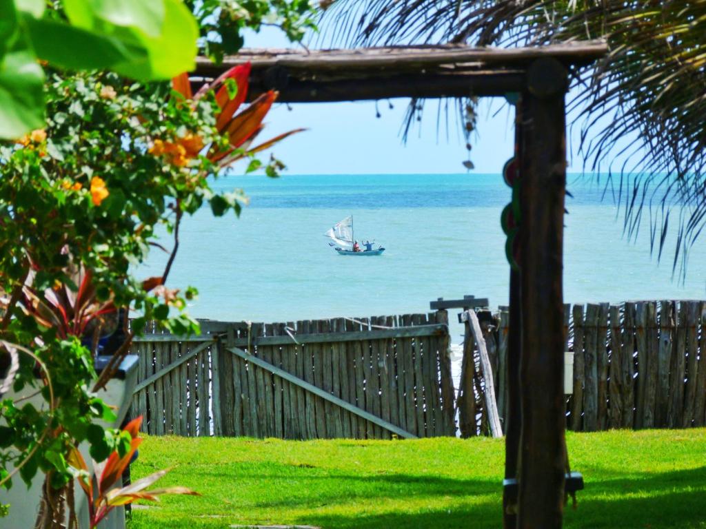 a boat in the ocean with a boat in the water at Casa Azul do Piauí in Luis Correia