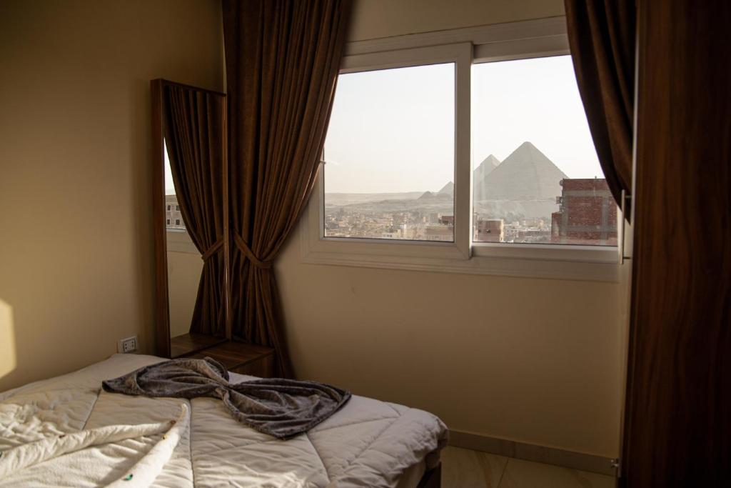 Een bed of bedden in een kamer bij Gardenia Pyramids view inn