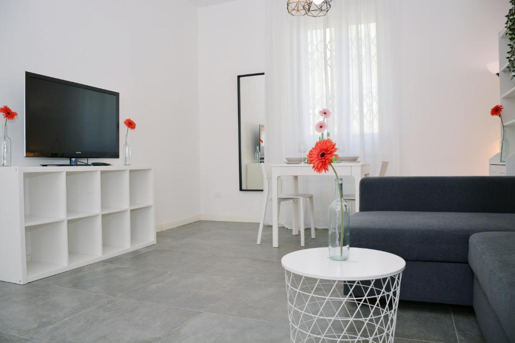 ein Wohnzimmer mit einem blauen Sofa und einem TV in der Unterkunft Florence Chic, garden and parking in Florenz