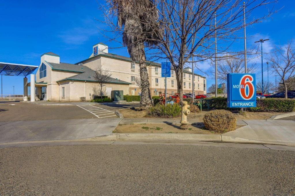 a building with a fire hydrant in a parking lot at Motel 6-Lemoore, CA in Lemoore