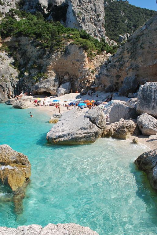 a group of people on a beach with rocks at Villa Maddalena con parcheggio privato in Baunei