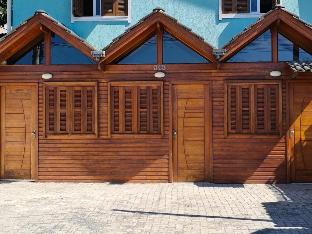 a wooden garage door on a blue building at Chales Dos Alpes in Canela