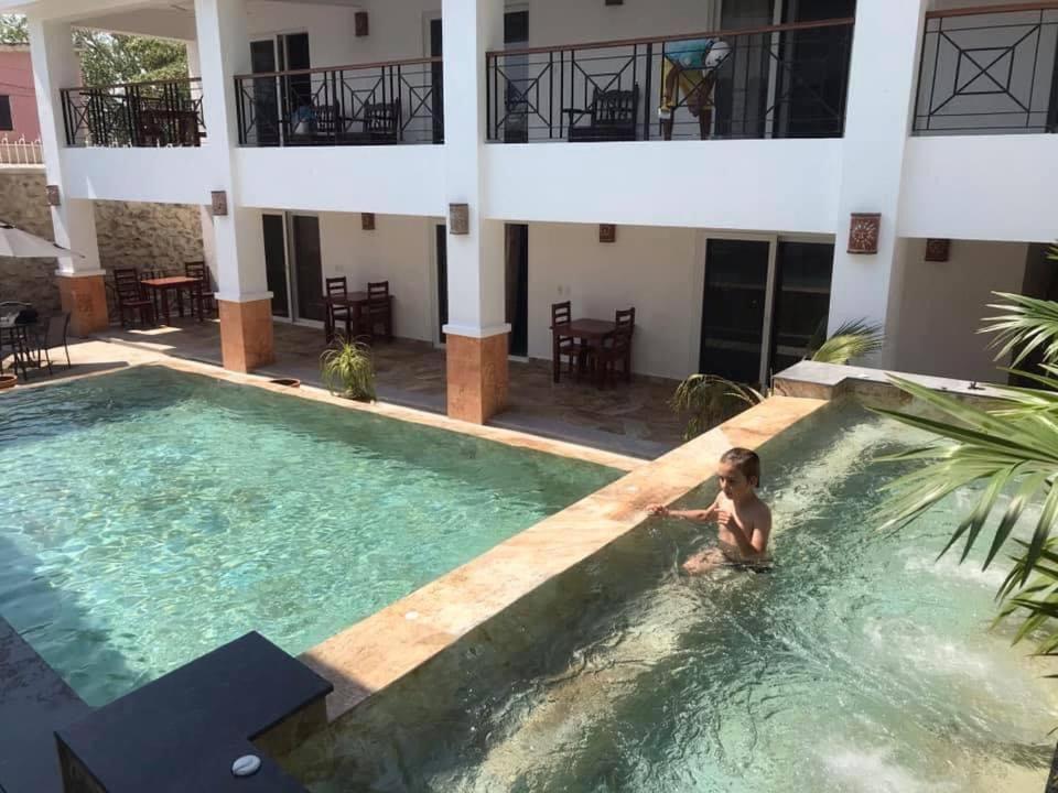 a woman in a pool in front of a building at Quinta Alberto Boutique Hotel in San Blas