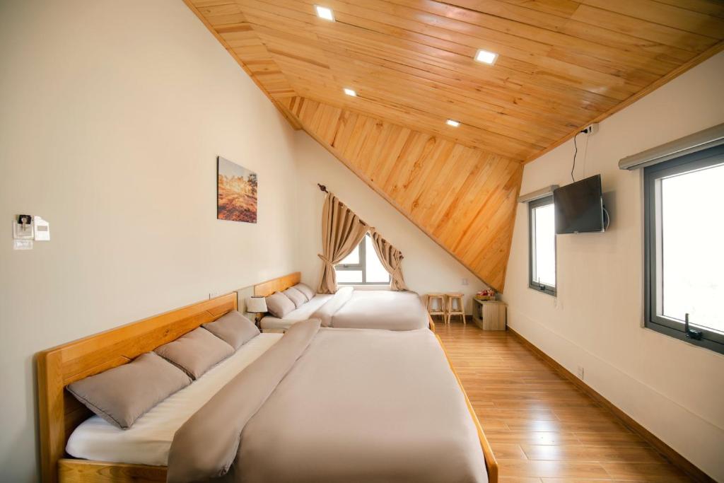 2 camas en una habitación con techos de madera en Let'Stay Homestay Da Lat, en Da Thien