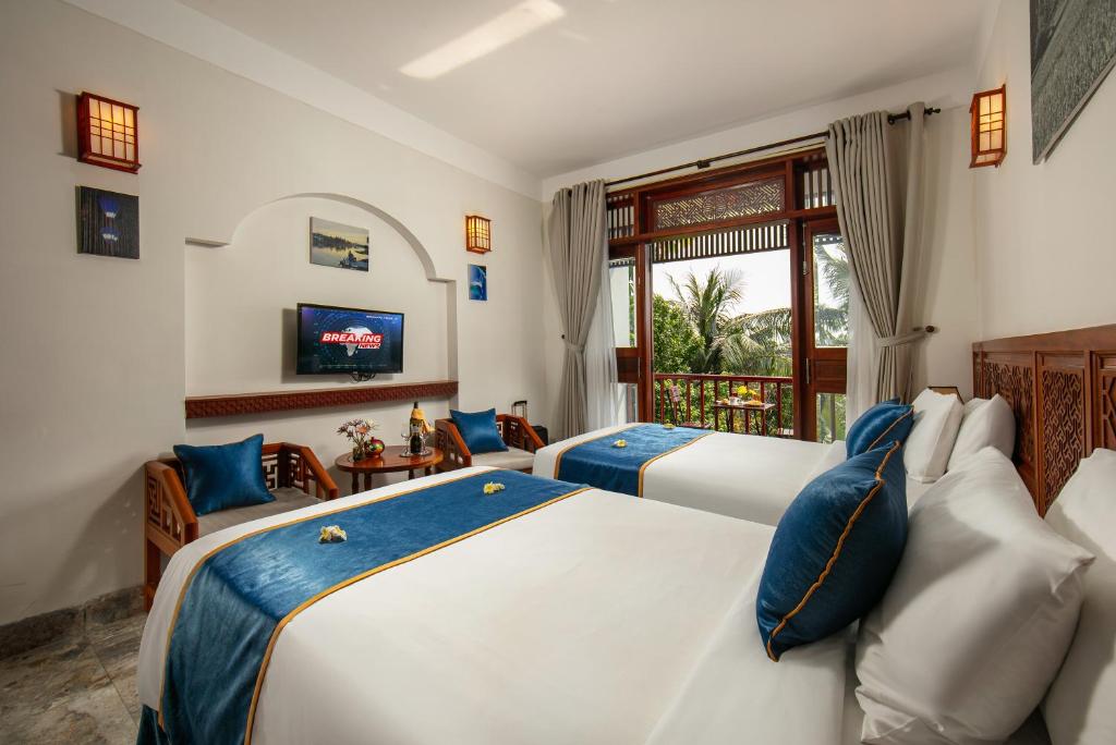 Postel nebo postele na pokoji v ubytování Hoi An Riverside Villas & Apartments