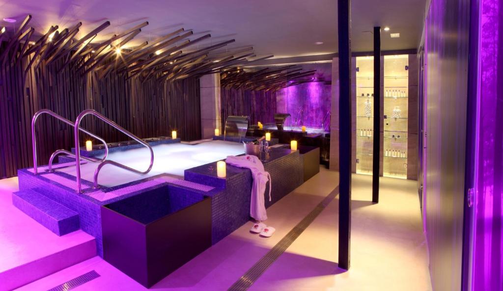 un baño púrpura con una bañera con velas. en Hotel Las Treixas, en Puebla de Sanabria