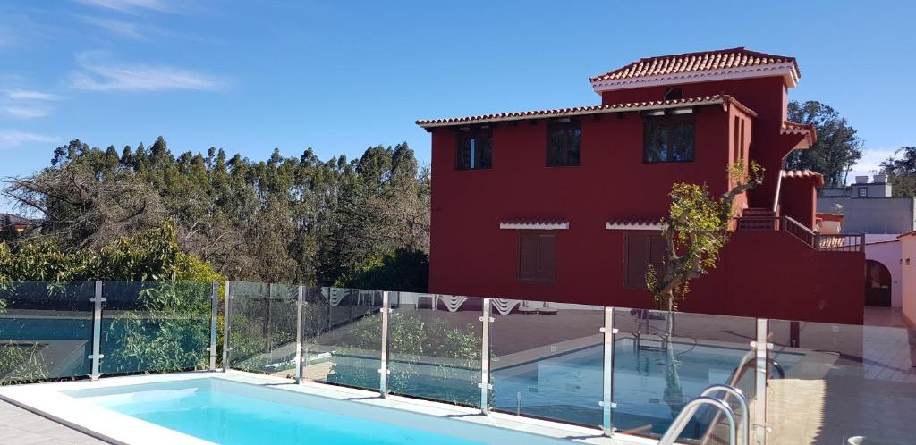 una casa con piscina frente a un edificio en Casitas Gutiérrez, en Moya