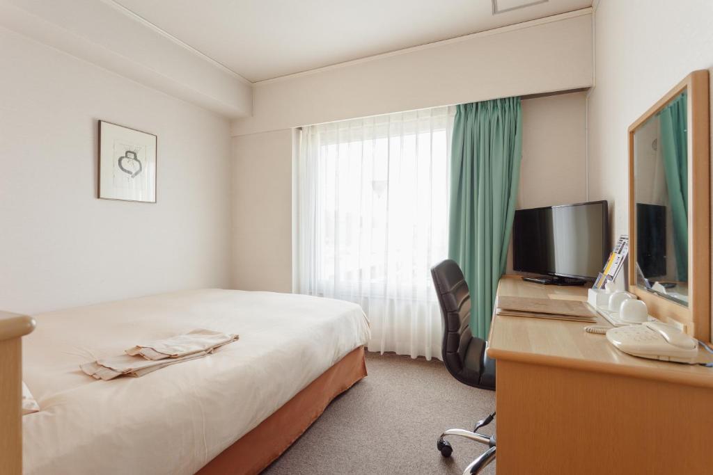 Postel nebo postele na pokoji v ubytování AkishimaStationHotel TOKYO