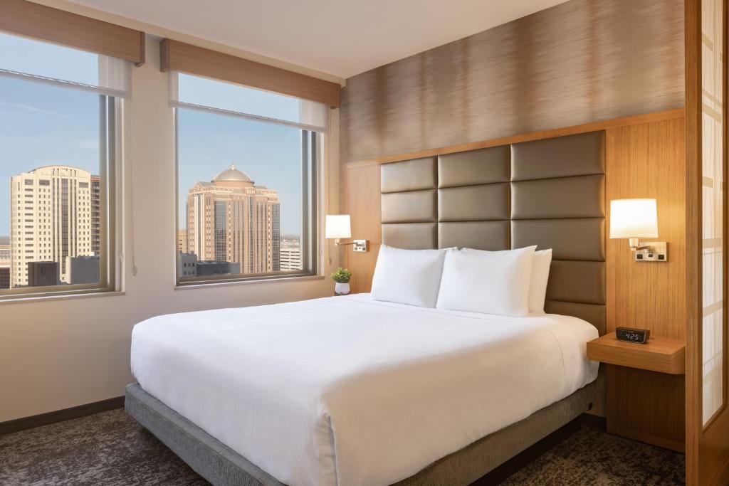 a bedroom with a large white bed and windows at Hyatt Place Houston Downtown in Houston