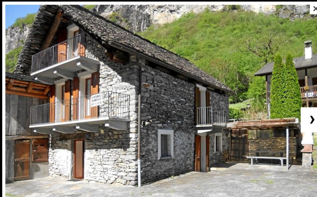 una casa de piedra con balcones en un lateral en Rustico Bietto, en Cevio
