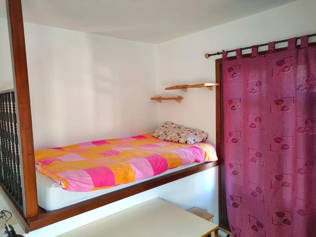 a bedroom with a bunk bed with a purple curtain at Acogedor duplex a 15min de Marbella in Monda
