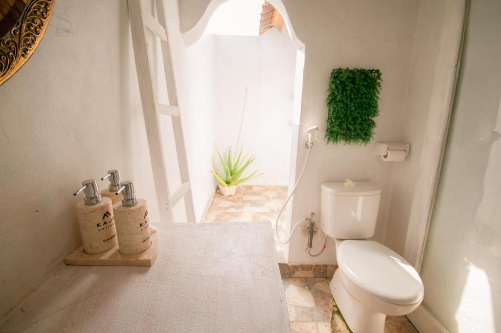 a bathroom with a toilet and a window at kaje cottage & restaurant in Nusa Penida