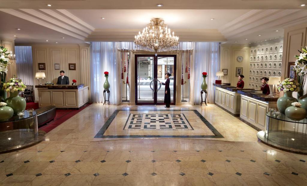 a hotel lobby with a woman standing at the front door at Sofitel Legend Metropole Hanoi in Hanoi