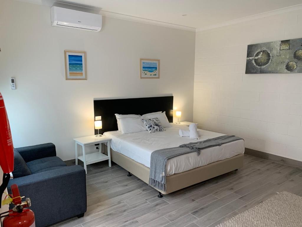a bedroom with a bed and a blue couch at BENDIGO HIGH ST APARTMENTS with KING BED-COURTYARD-KITCHEN-REFURBISHED 2022 in Bendigo