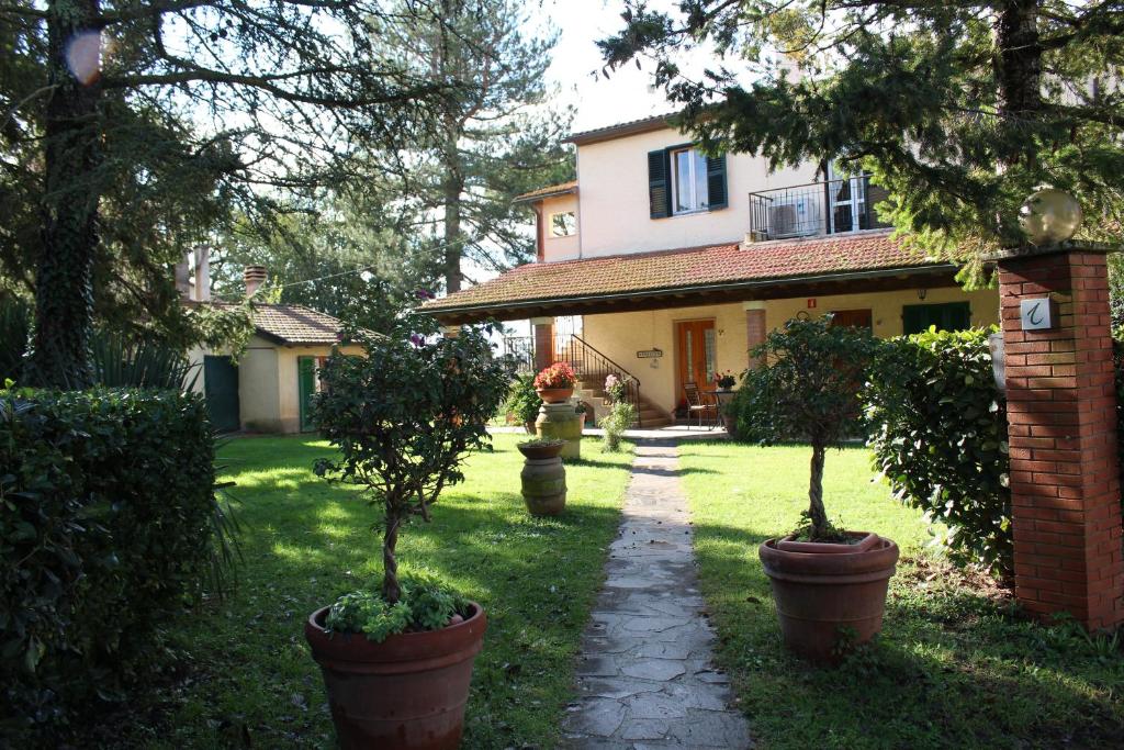 uma casa com dois vasos de árvores em frente em Agriturismo Le Chicche di Mafalda em Montemerano