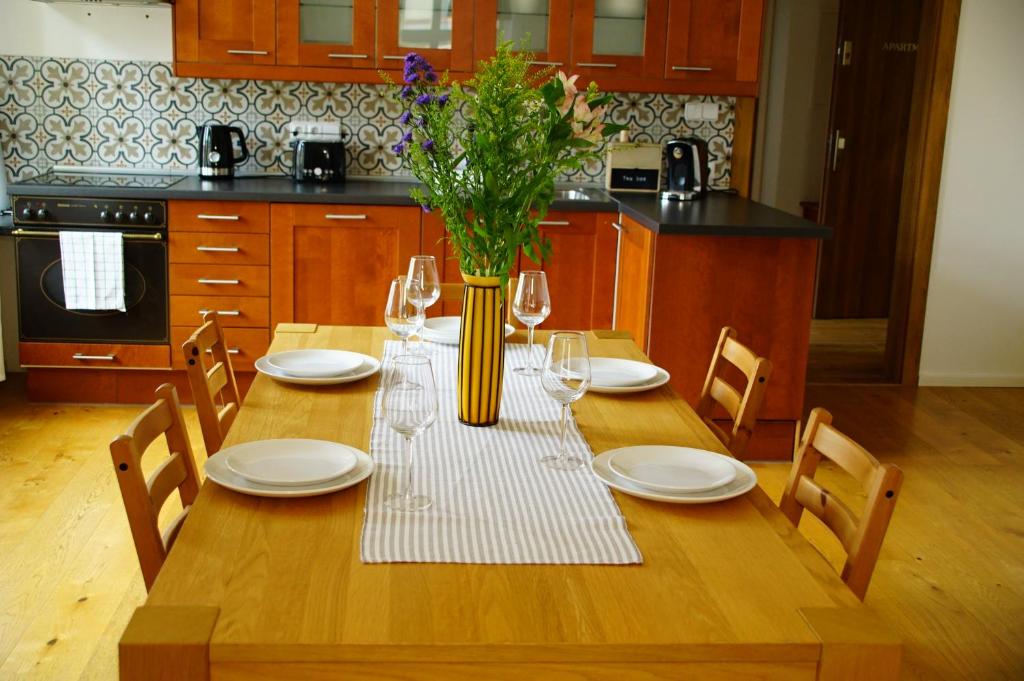 a wooden table with a vase of flowers on it at Apartmány u komína in Terezín