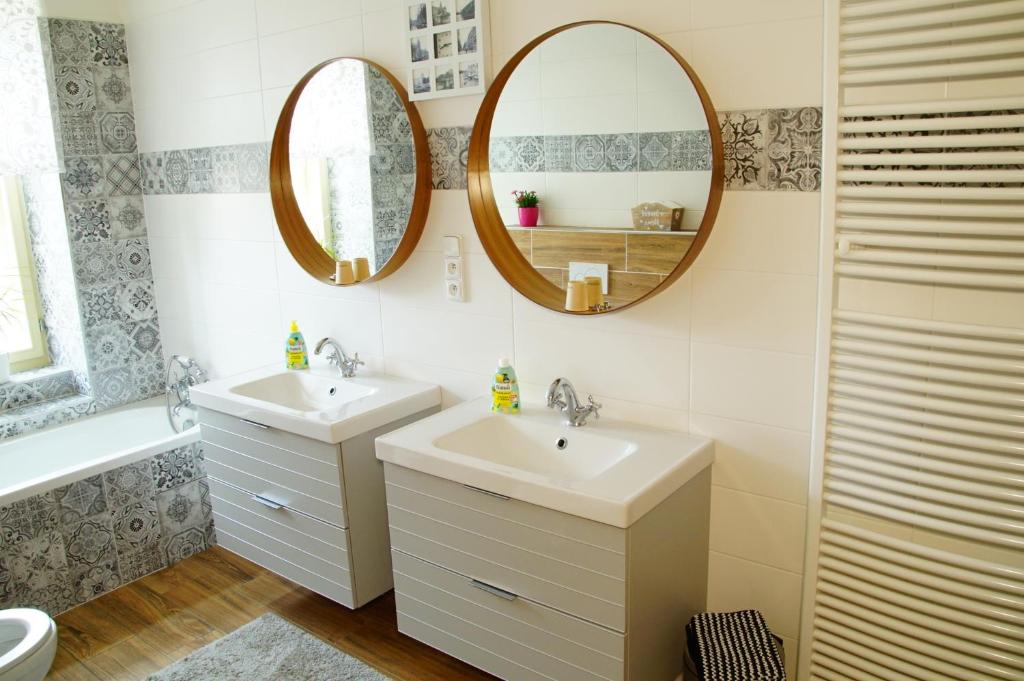 a bathroom with two sinks and a mirror at Apartmány u komína in Terezín