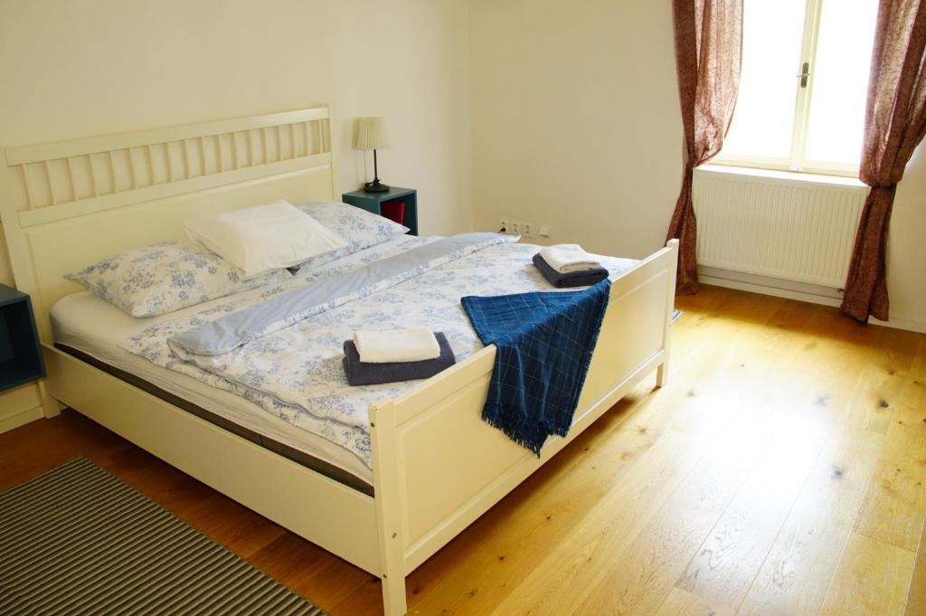 a bedroom with a white bed with two towels on it at Apartmány u komína in Terezín