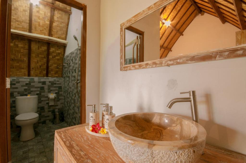 a bathroom with a large sink and a toilet at kaje cottage & restaurant in Nusa Penida