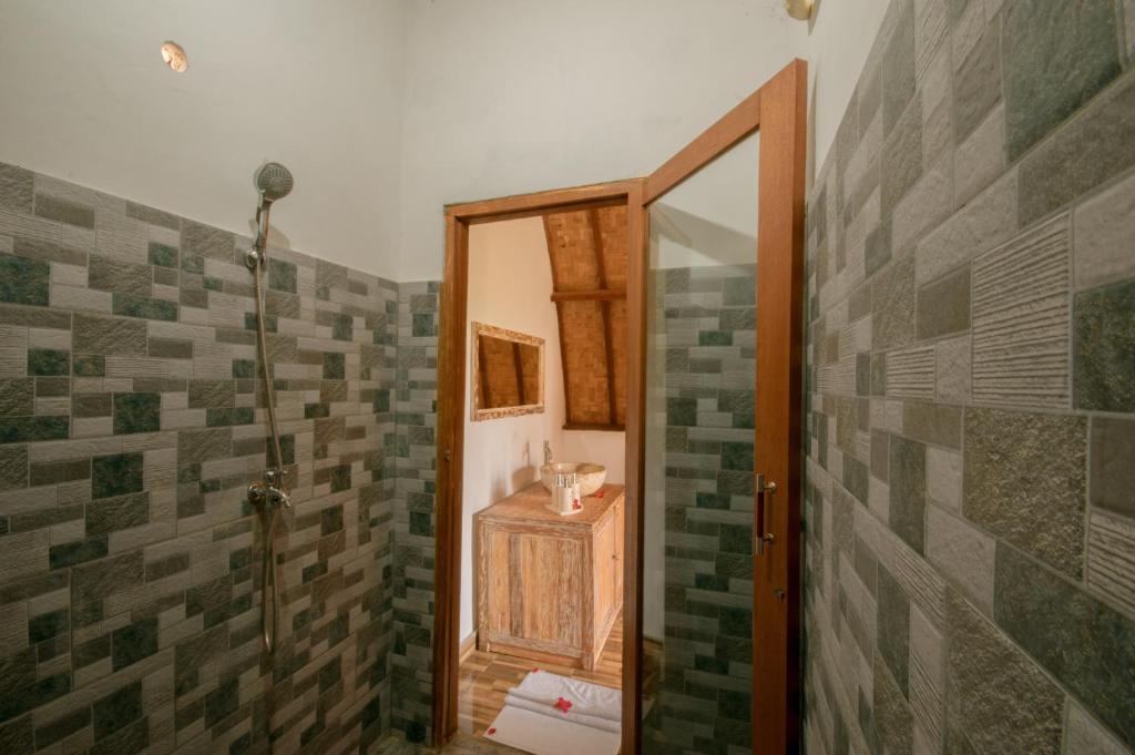 a bathroom with a shower with green and gray tiles at kaje cottage & restaurant in Nusa Penida
