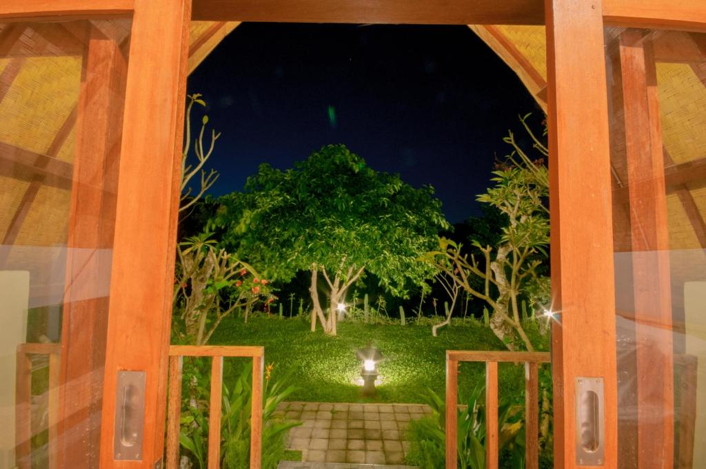 a view from the door of a garden at night at kaje cottage & restaurant in Nusa Penida
