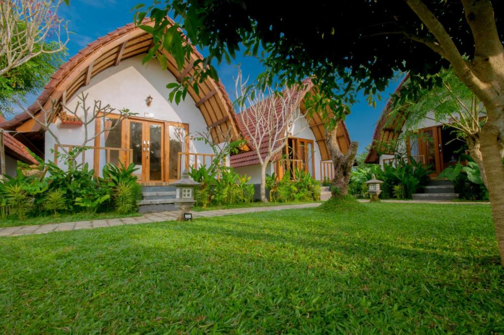 a house with a straw roof at kaje cottage & restaurant in Nusa Penida