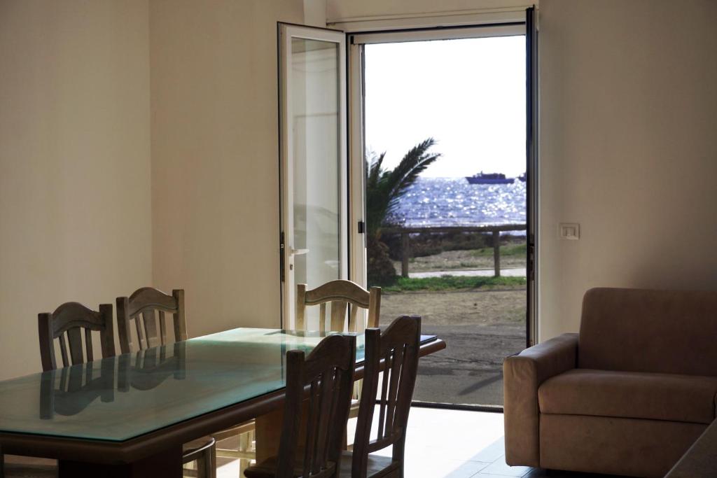 Viva Vista Mare Trilo PianoTerra في بورتو سيساريو: غرفة طعام مع طاولة وكراسي وأريكة
