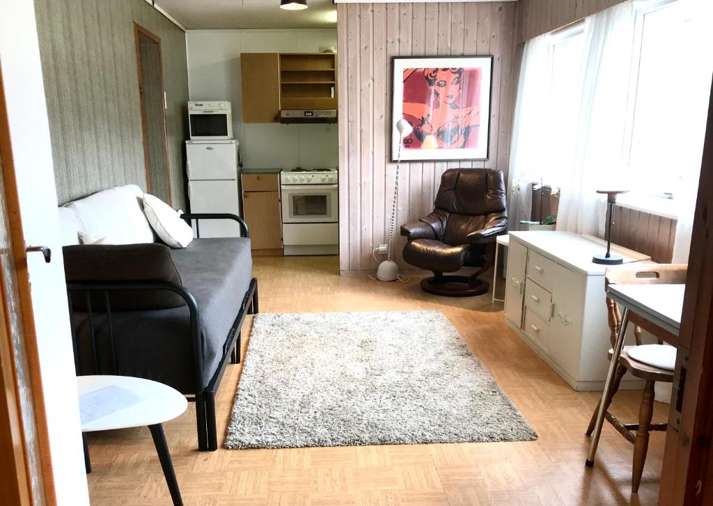 バレストランドにあるVilla Holmen 2 - Ground floor apartmentの小さなリビングルーム(ソファ、椅子付)