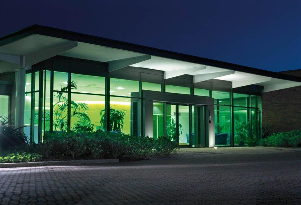 ein großes Gebäude mit Glasfenstern in der Nacht in der Unterkunft Roffey Park Institute in Horsham