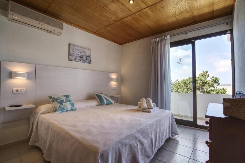 a bedroom with a bed and a large window at Hotel Rosamar - Emar Hotels in Es Pujols