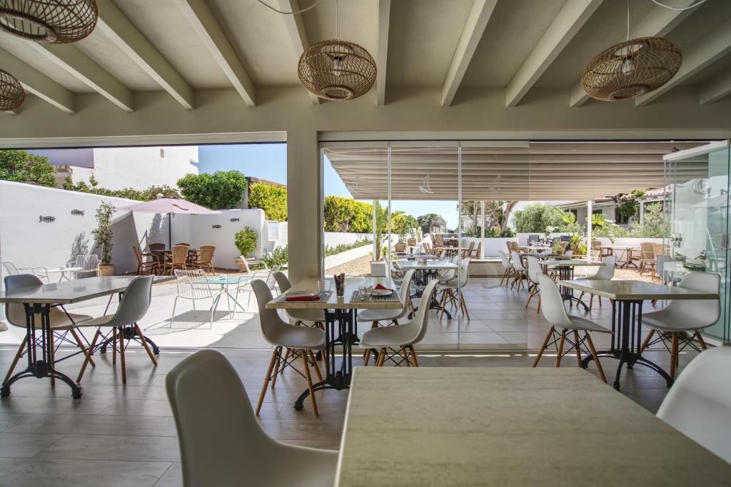 a restaurant with tables and chairs on a patio at Hotel Rosamar - Emar Hotels in Es Pujols