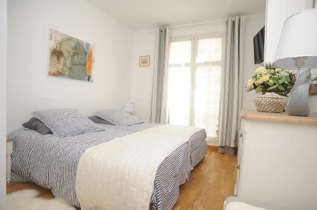 une chambre blanche avec un lit et une fenêtre dans l'établissement L'Esplanade, à Dieppe