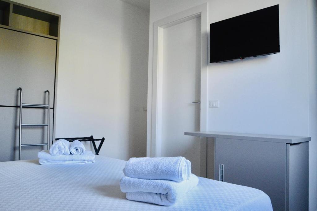a bedroom with towels on a bed with a television at Casa Lighea Mondello - 200 mt dalla spiaggia in Mondello