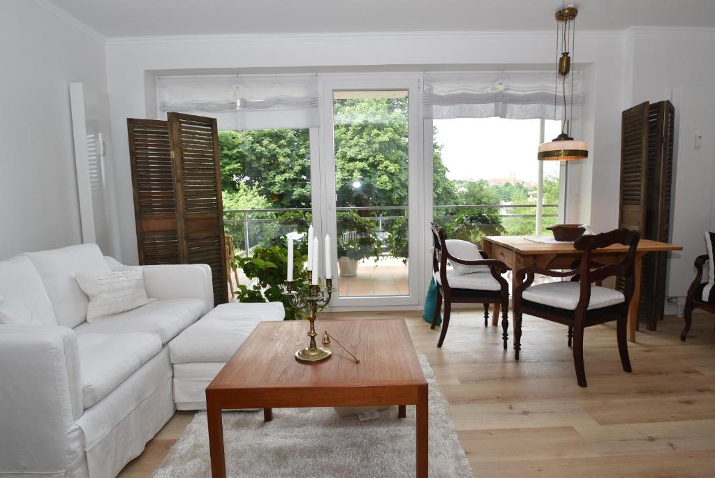 a living room with a white couch and a table at fewo1846 - Belvedere - behaglich ausgestattete Wohnung mit Balkon und Hafenblick in Flensburg