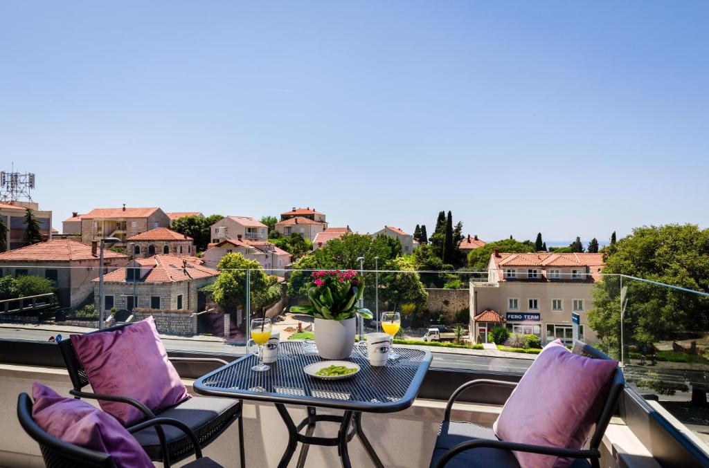 una mesa y sillas en un balcón con vistas en Apartments ZoomZoom en Dubrovnik