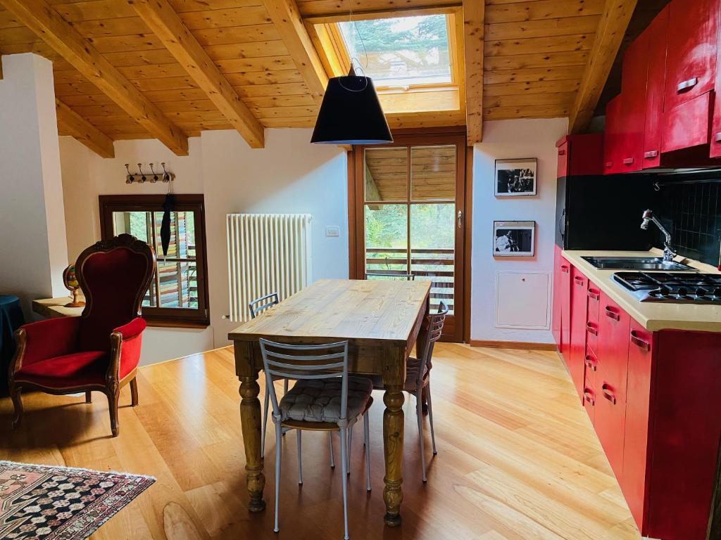 a kitchen with a wooden table and red cabinets at La Casa al Torrente in Riva del Garda