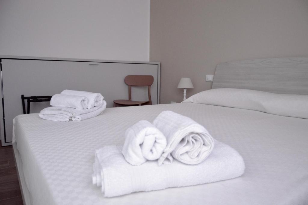 a hotel room with two beds with white towels at Casa Lighea Mondello - 200 mt dalla spiaggia in Mondello