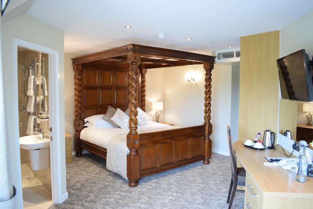 um quarto com uma cama de dossel e um lavatório em The Chase Golf & Country Club em Penkridge