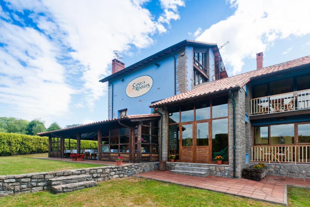 a blue building with large windows at Hotel Costa de Rodiles in Selorio