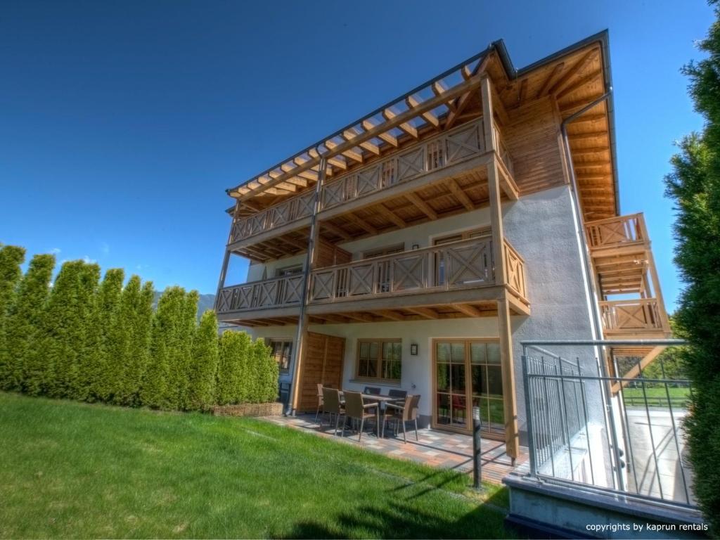 a house with a wrap around deck with a lawn at Residenz an der Burg by Kaprun Rentals in Kaprun